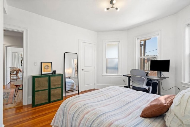 bedroom featuring baseboards and wood finished floors