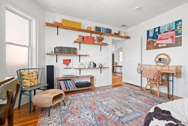 sitting room with visible vents, wood finished floors, and baseboards