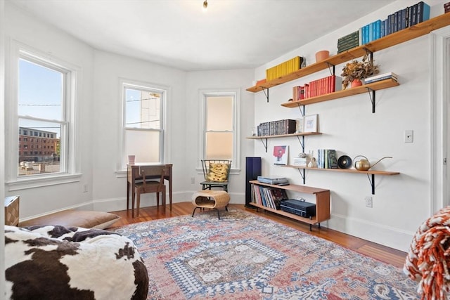 sitting room with baseboards and wood finished floors