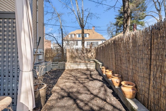 view of yard with central AC and a fenced backyard