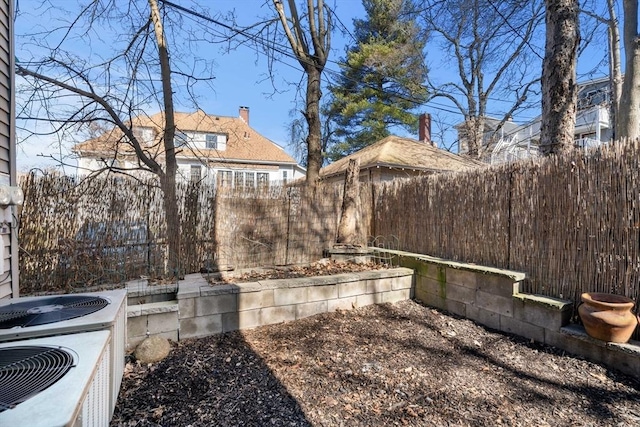 view of yard with central air condition unit and fence