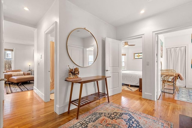 hallway featuring recessed lighting, light wood-type flooring, and baseboards