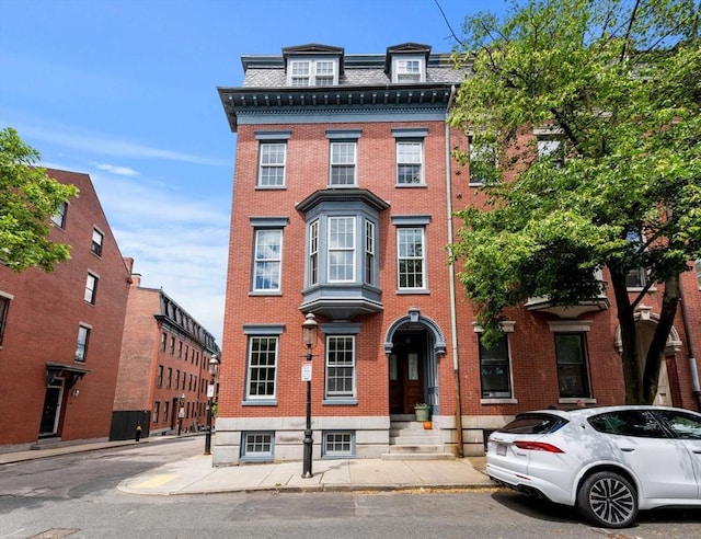 victorian home with brick siding and mansard roof