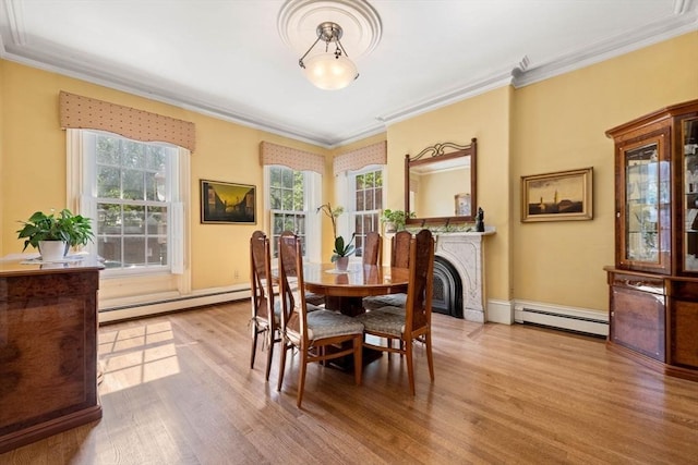 dining area featuring ornamental molding, a baseboard radiator, and wood finished floors