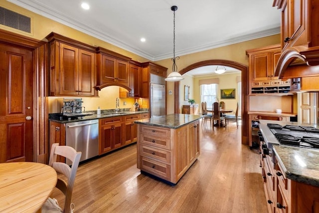 kitchen featuring stainless steel appliances, arched walkways, visible vents, and light wood finished floors