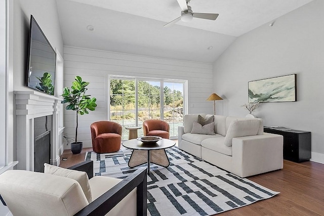 living room with dark hardwood / wood-style flooring, ceiling fan, lofted ceiling, and wood walls