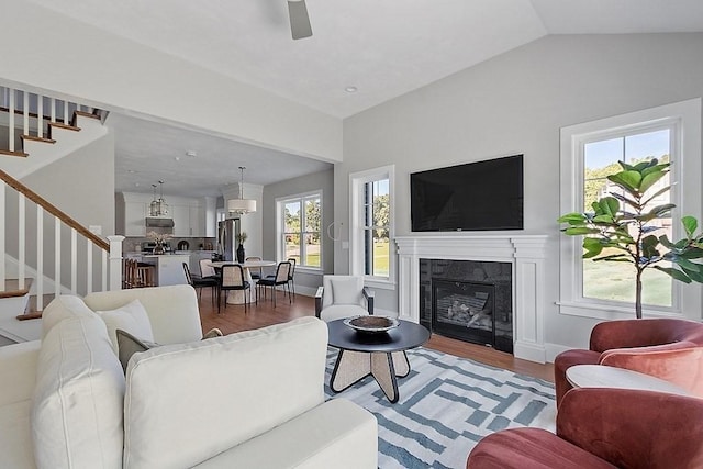 living room with a fireplace, lofted ceiling, and hardwood / wood-style flooring