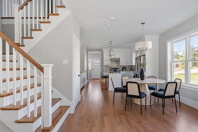 dining room with a wealth of natural light, dark hardwood / wood-style floors, and a notable chandelier