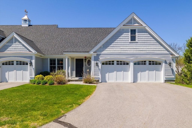 view of front facade featuring a garage, aphalt driveway, a front yard, and a shingled roof