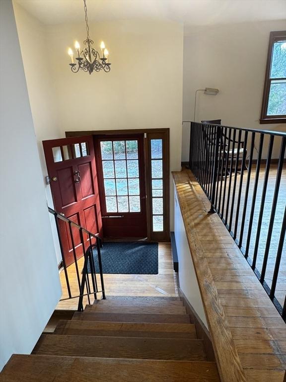 stairs with a chandelier and wood-type flooring