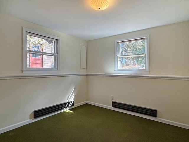 spare room with baseboards, visible vents, and dark colored carpet