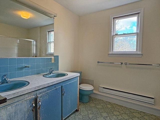 bathroom featuring a sink, a baseboard radiator, toilet, and a stall shower