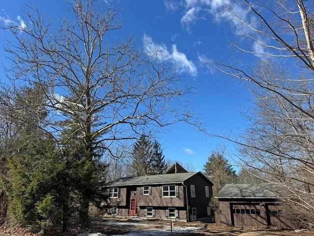 split foyer home featuring entry steps, an outbuilding, and a garage