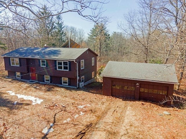 view of property exterior with a garage, an outbuilding, and driveway