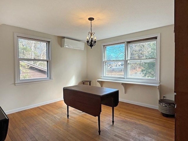 office area with baseboards, hardwood / wood-style flooring, a chandelier, and a wall mounted AC