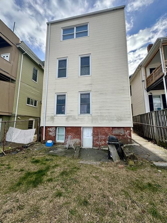 rear view of house featuring a lawn