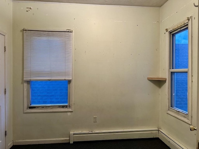 unfurnished room featuring baseboard heating