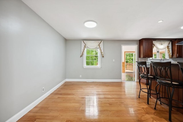 451 Lincoln St, Abington, MA 02351 - kitchen featuring baseboards, a kitchen breakfast bar, light wood-type flooring, dark brown cabinetry, and recessed lighting