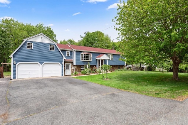 451 Lincoln St, Abington, MA 02351 - split foyer home featuring a garage, asphalt driveway, a front yard, a gambrel roof, and stone siding