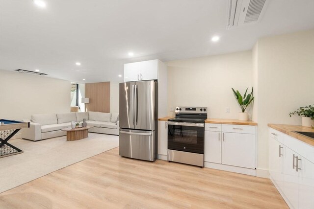 33 Conwell Ave, Somerville, MA 02144 - kitchen featuring appliances with stainless steel finishes, light wood-style floors, white cabinets, butcher block countertops, and recessed lighting