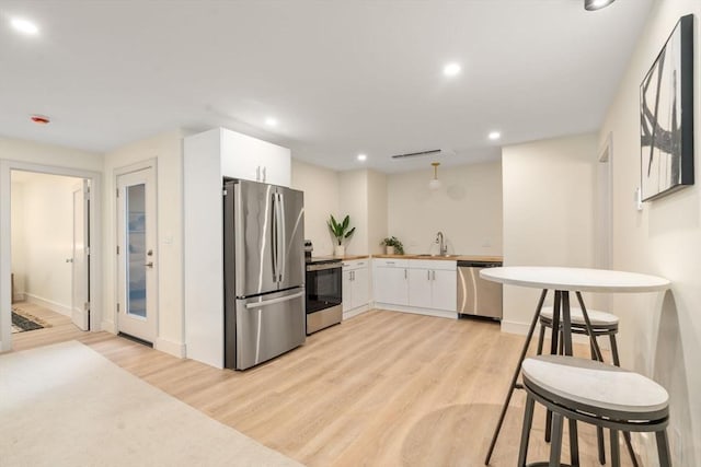 33 Conwell Ave, Somerville, MA 02144 - kitchen with stainless steel appliances, light wood-type flooring, white cabinetry, and recessed lighting