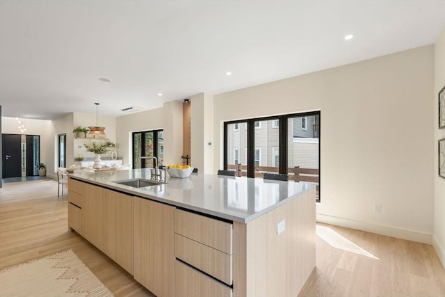 33 Conwell Ave, Somerville, MA 02144 - kitchen featuring modern cabinets, light brown cabinetry, light wood-style flooring, a large island with sink, and light countertops