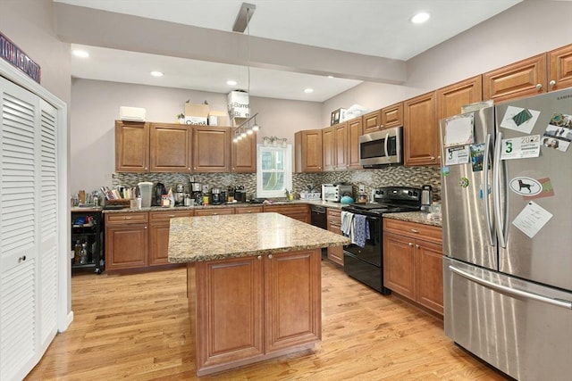 kitchen with light stone counters, brown cabinets, black appliances, and light wood finished floors