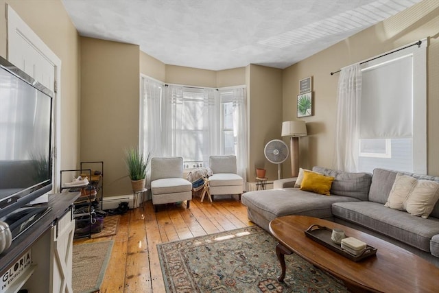 living area with light wood-style flooring and a baseboard radiator