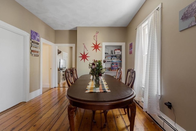 dining area featuring baseboards and light wood-style flooring