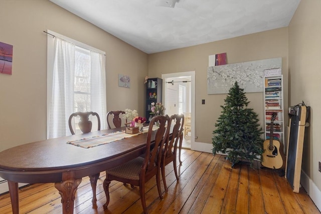 dining space with light wood finished floors and baseboards