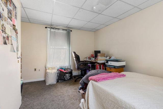 carpeted bedroom with a paneled ceiling and baseboards