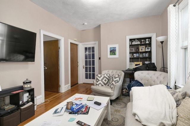 living area featuring baseboards and wood finished floors