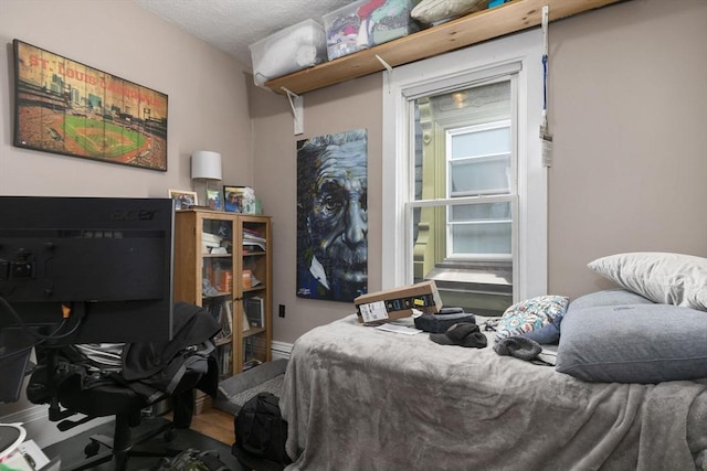 bedroom with a textured ceiling and baseboards