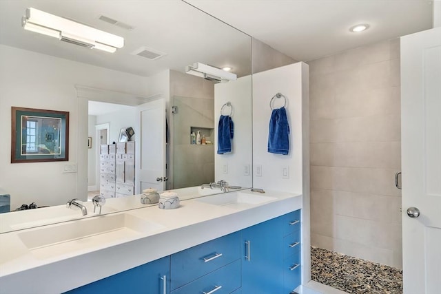bathroom with double vanity, a sink, visible vents, and a shower stall