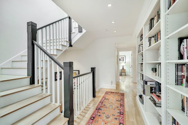 hallway featuring recessed lighting, light wood finished floors, baseboards, and stairway