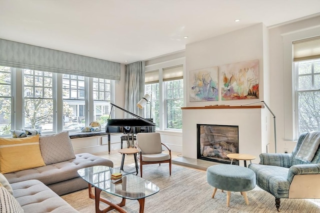 sitting room featuring a fireplace with raised hearth and light wood-type flooring