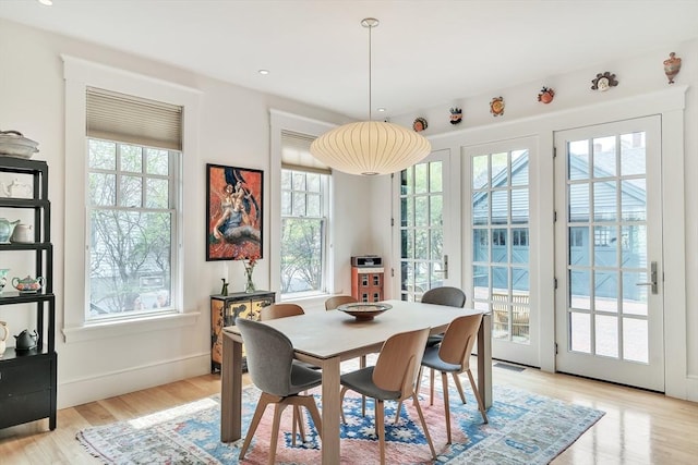 dining room with light wood-style floors, baseboards, and recessed lighting
