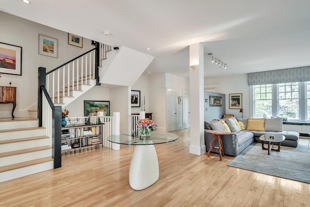 living area with recessed lighting, baseboards, stairway, and light wood-type flooring