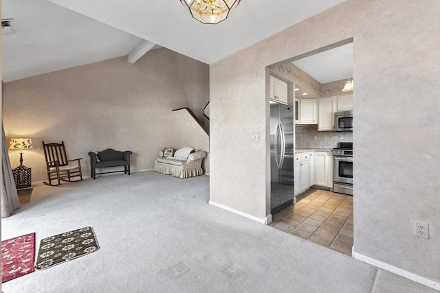 kitchen featuring white cabinetry, vaulted ceiling with beams, light colored carpet, and stainless steel appliances