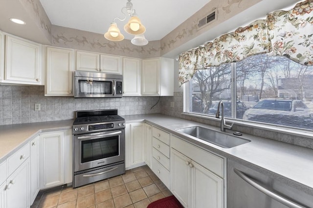 kitchen featuring white cabinets, visible vents, stainless steel appliances, and a sink