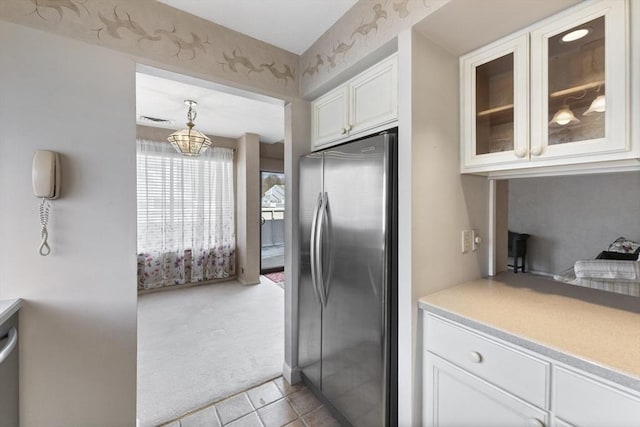 kitchen featuring light carpet, glass insert cabinets, freestanding refrigerator, light countertops, and white cabinetry