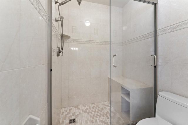 bathroom featuring a stall shower and toilet