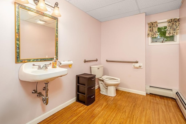 18 Main St, Templeton, MA 01468 - bathroom featuring a baseboard radiator, toilet, baseboards, wood finished floors, and a drop ceiling