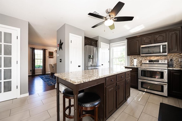 758 Council Oak Way, Dighton, MA 02715 - kitchen featuring stainless steel appliances, dark brown cabinets, tasteful backsplash, and light stone counters