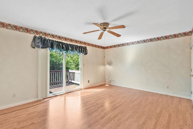 empty room with ceiling fan, wood finished floors, and baseboards