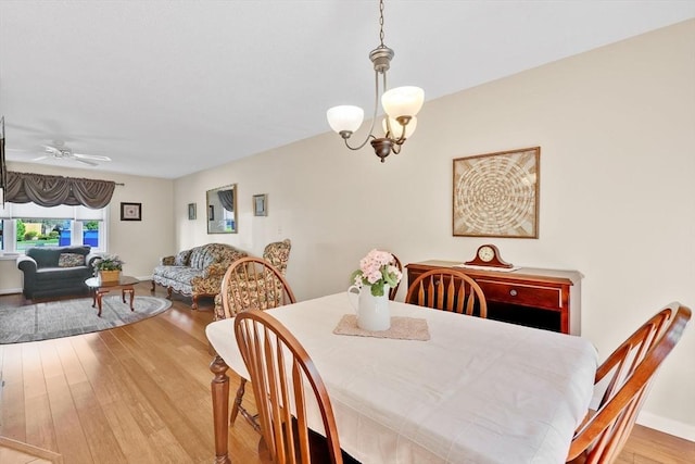 dining room featuring wood finished floors, a chandelier, and a ceiling fan