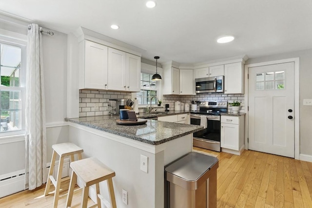 905 Stony Hill Rd, Wilbraham, MA 01095 - kitchen with appliances with stainless steel finishes, white cabinetry, backsplash, a breakfast bar, and recessed lighting