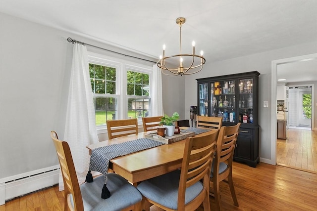 905 Stony Hill Rd, Wilbraham, MA 01095 - dining area featuring a chandelier, baseboard heating, light wood-style flooring, and baseboards