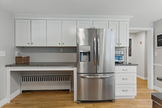 905 Stony Hill Rd, Wilbraham, MA 01095 - kitchen featuring stainless steel refrigerator with ice dispenser, radiator, white cabinetry, dark stone counters, and light wood-style flooring
