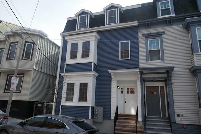 view of front of home featuring entry steps and mansard roof